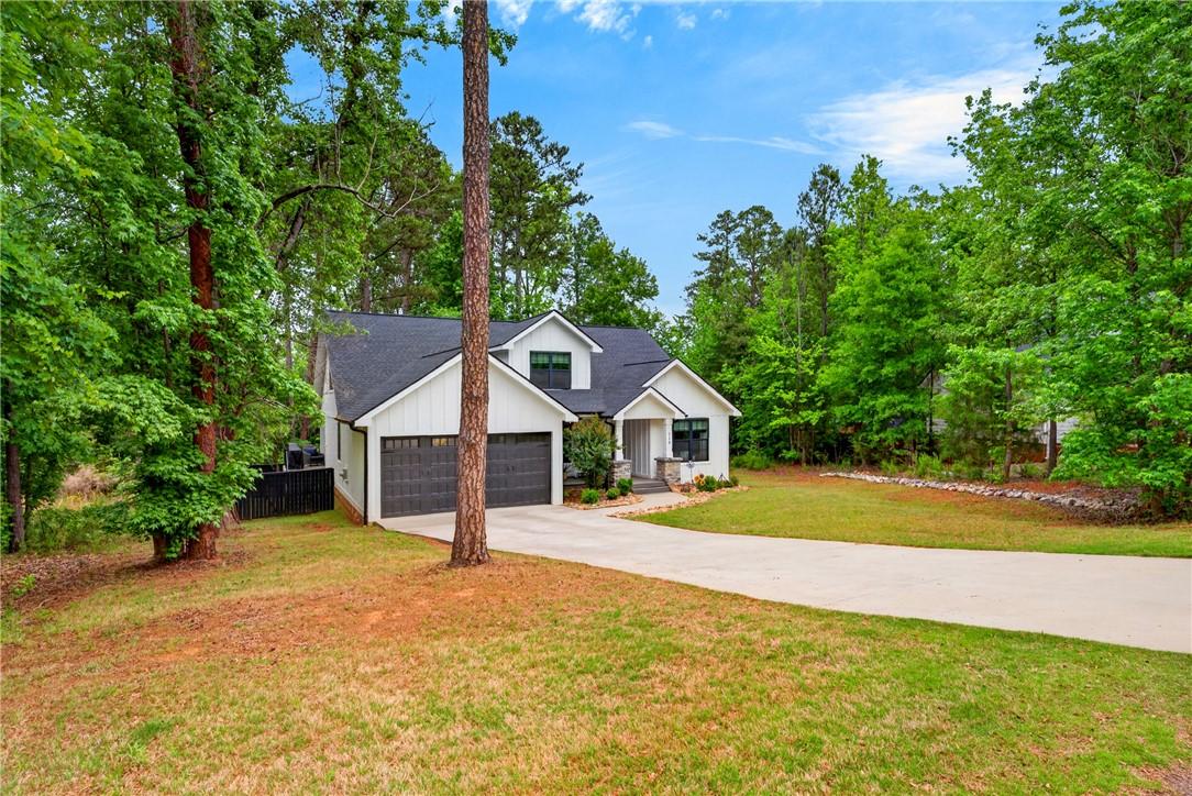 Image 3: This modern home offers a spacious driveway, provi