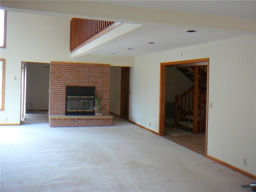 Image 4: This living room features a classic brick fireplac