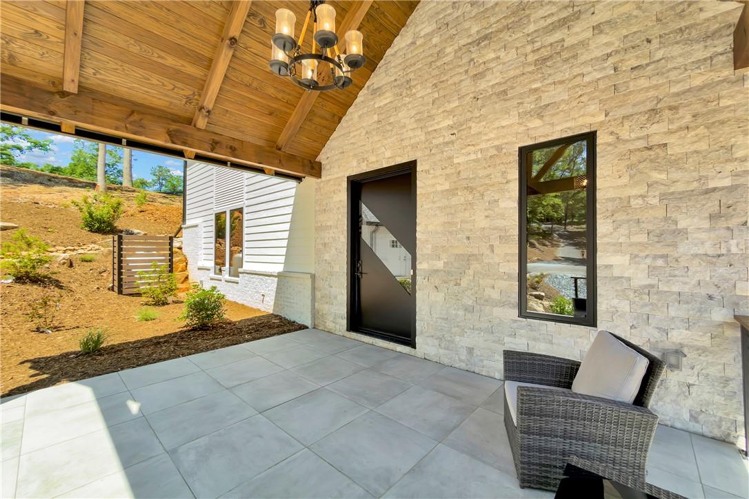 Image 3: A welcoming patio with stone walls and a rustic wo