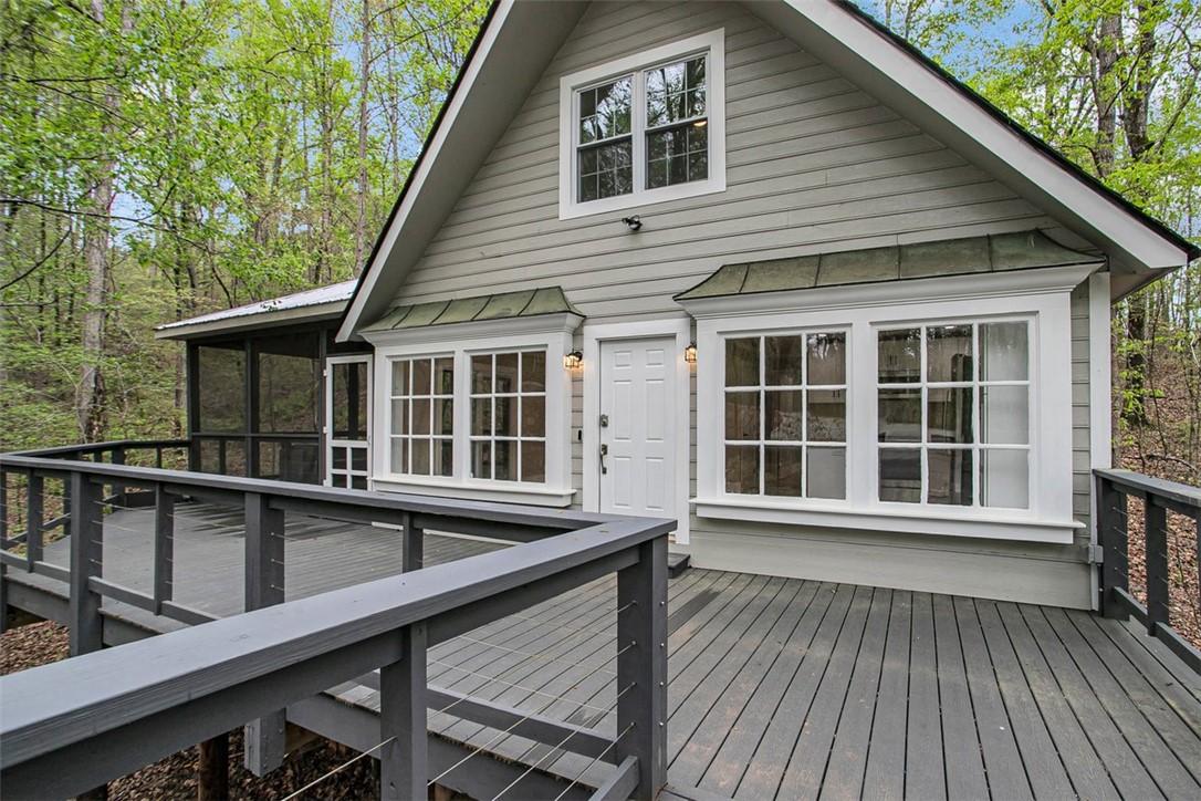 Image 1: A welcoming front porch with wood siding and a dec