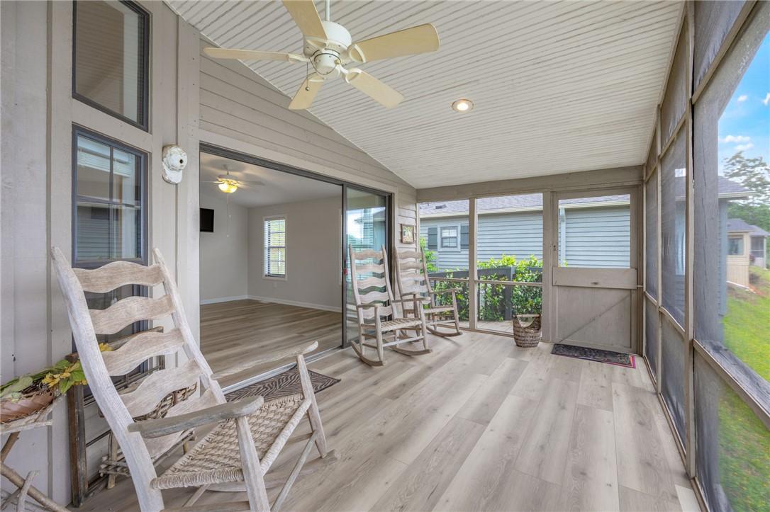 Image 2: A well-lit screened porch offers relaxation and vi