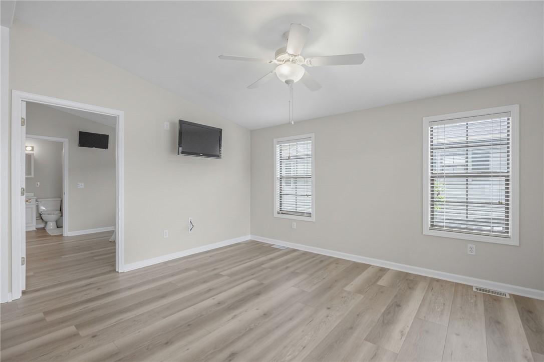 Image 4: A pristine bedroom retreat with light wood-tone fl
