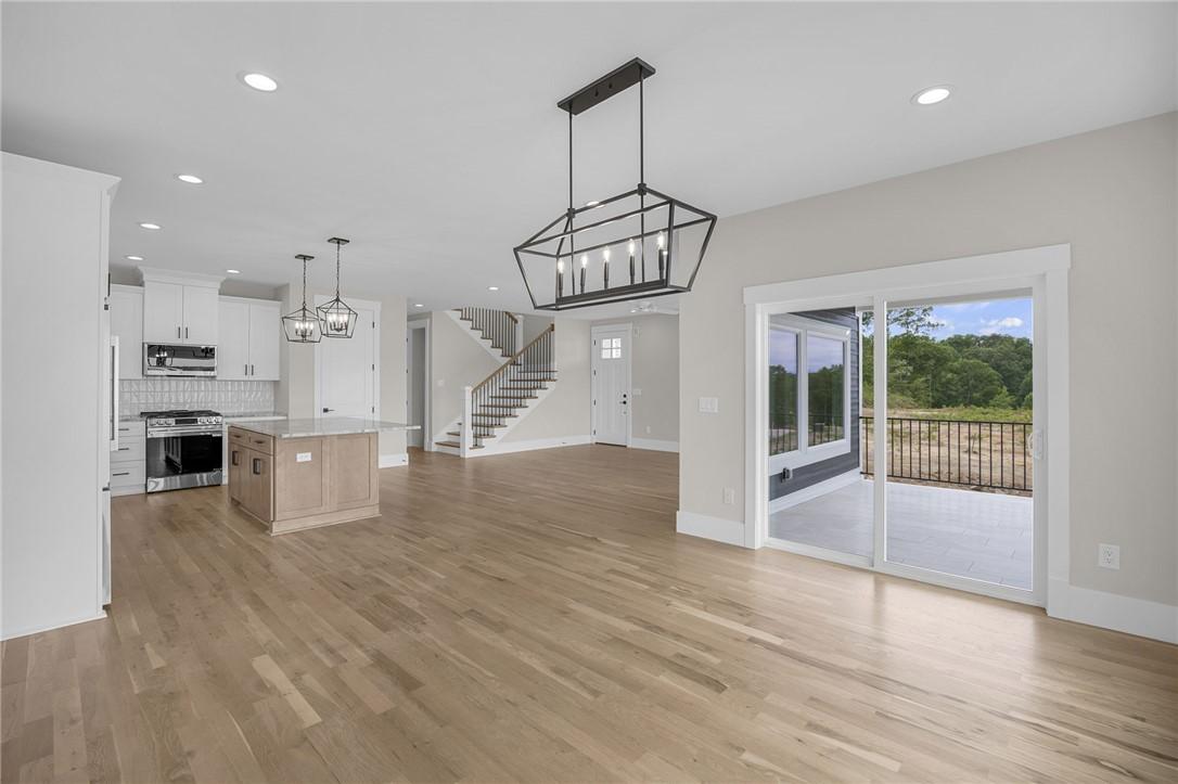 Image 3: An open-concept living space with hardwood floors,