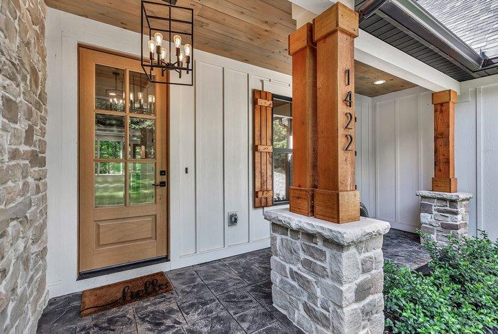 Image 2: A welcoming entry featuring a wooden front door, r