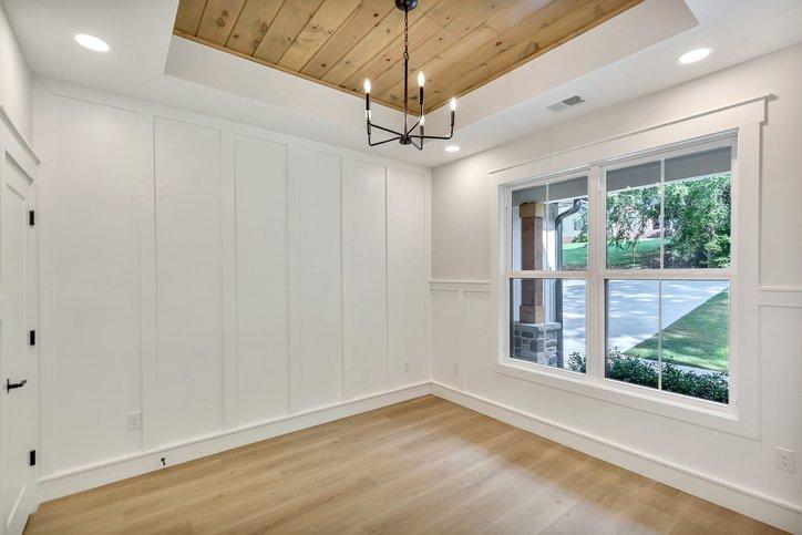 Image 4: A well-lit room boasts warm wood flooring and a st