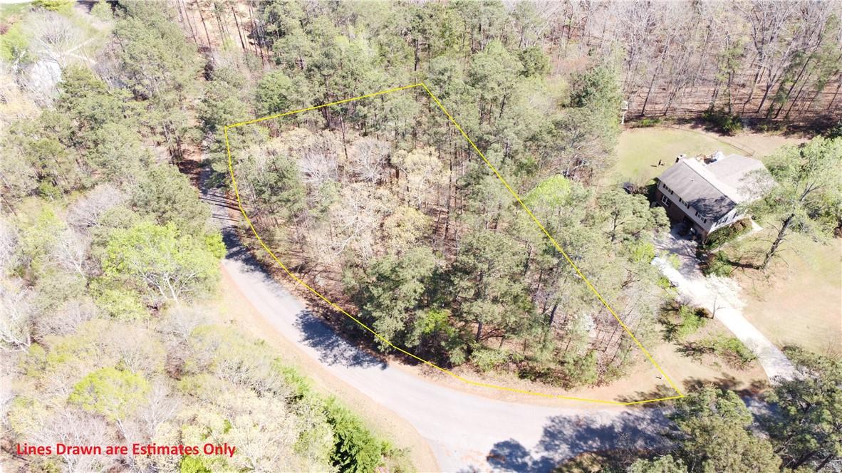Image 1: This aerial view showcases a peaceful, wooded lot