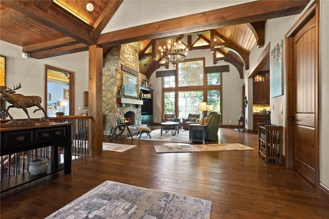 Image 3: Natural wood floors complement a stone fireplace a
