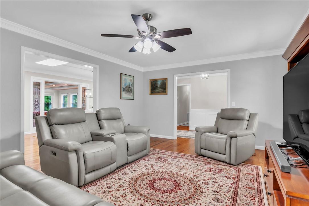 Image 4: This inviting living room features gleaming hardwo