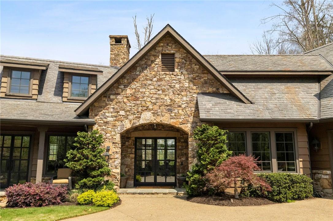 Image 2: This charming home showcases a stone facade and a