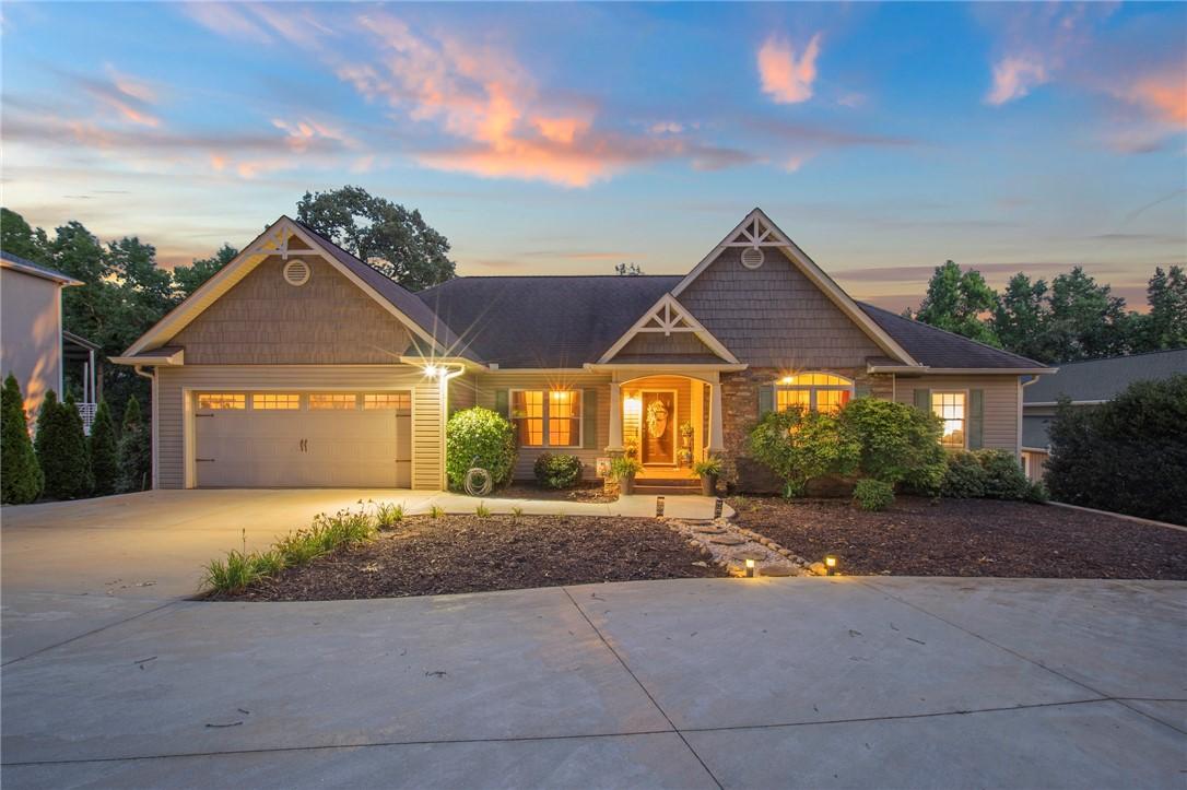 Image 1: Illuminated at dusk, this home presents a welcomin