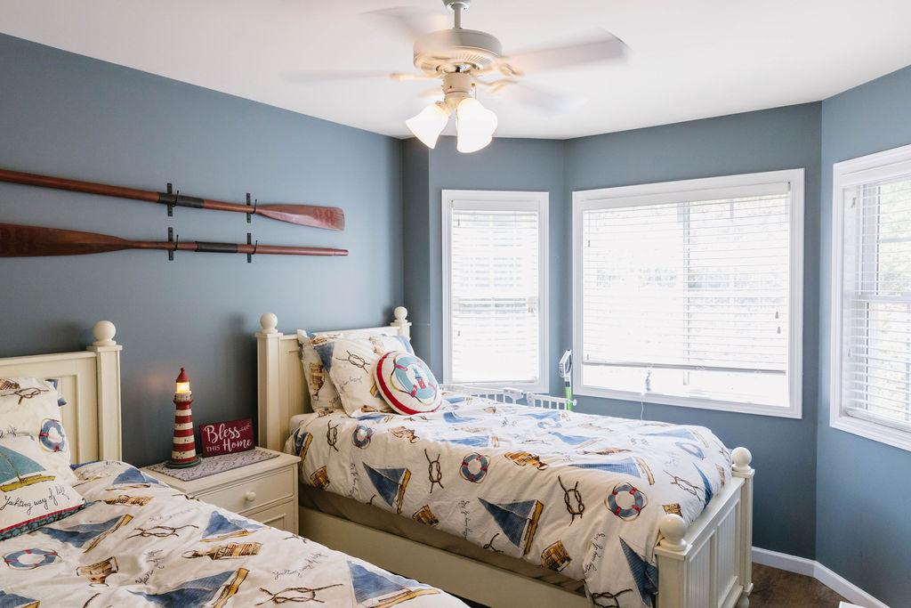 Image 3: This cozy bedroom features bright windows and a ce