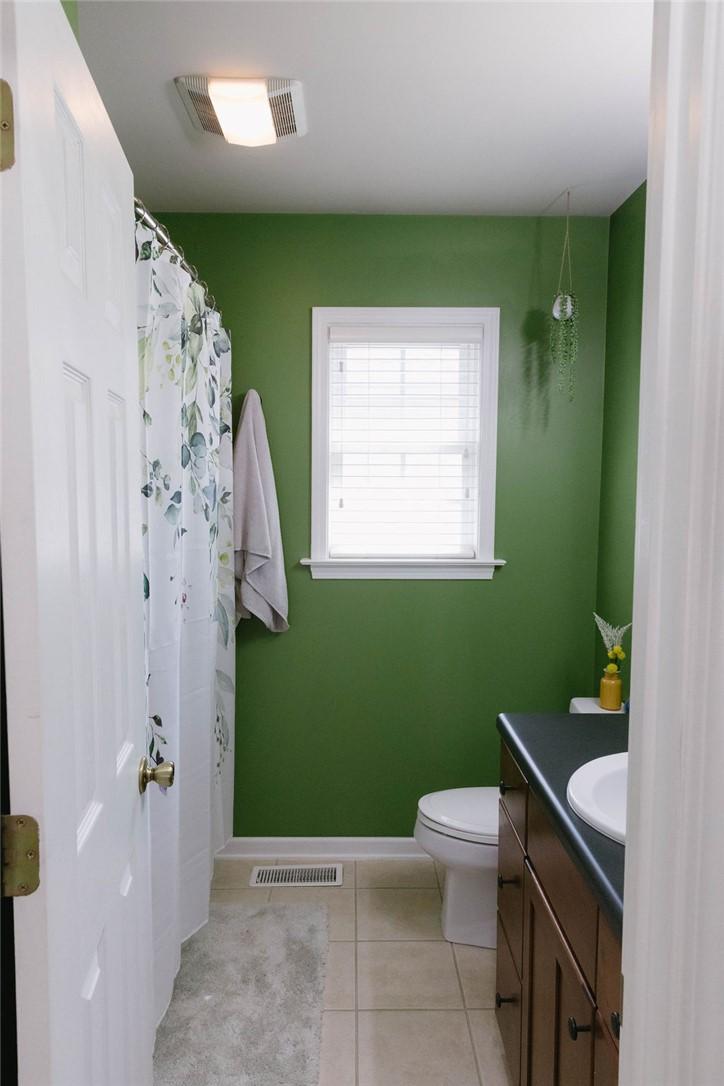 Image 4: This functional bathroom features a neutral tile f