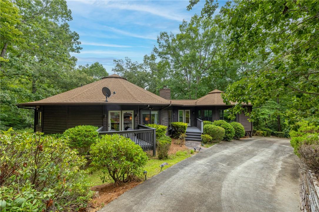 Image 1: Rising from a wooded 1.17-acre interior lot with w