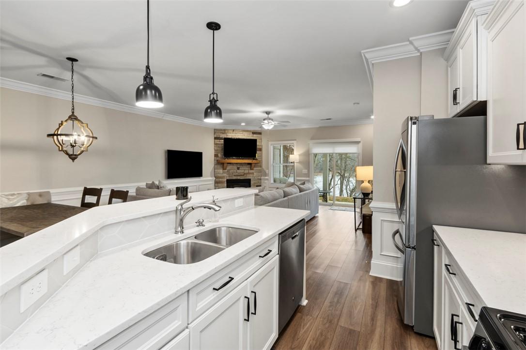 Image 3: An open concept living area features a kitchen wit