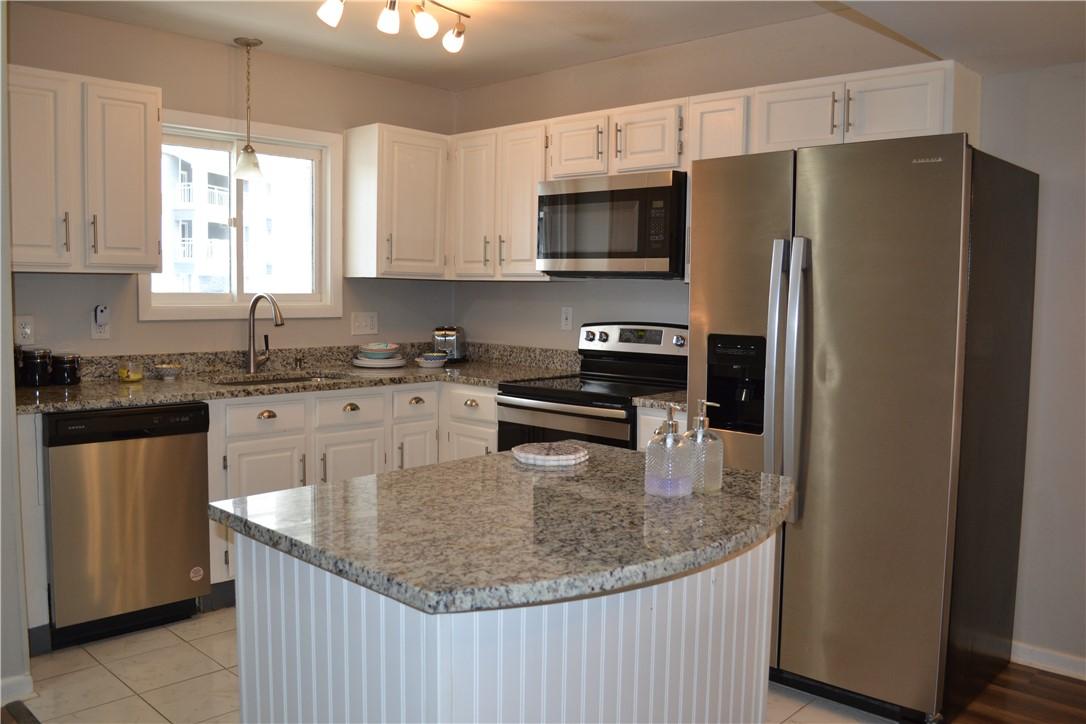 Image 3: This modern kitchen features elegant countertops,