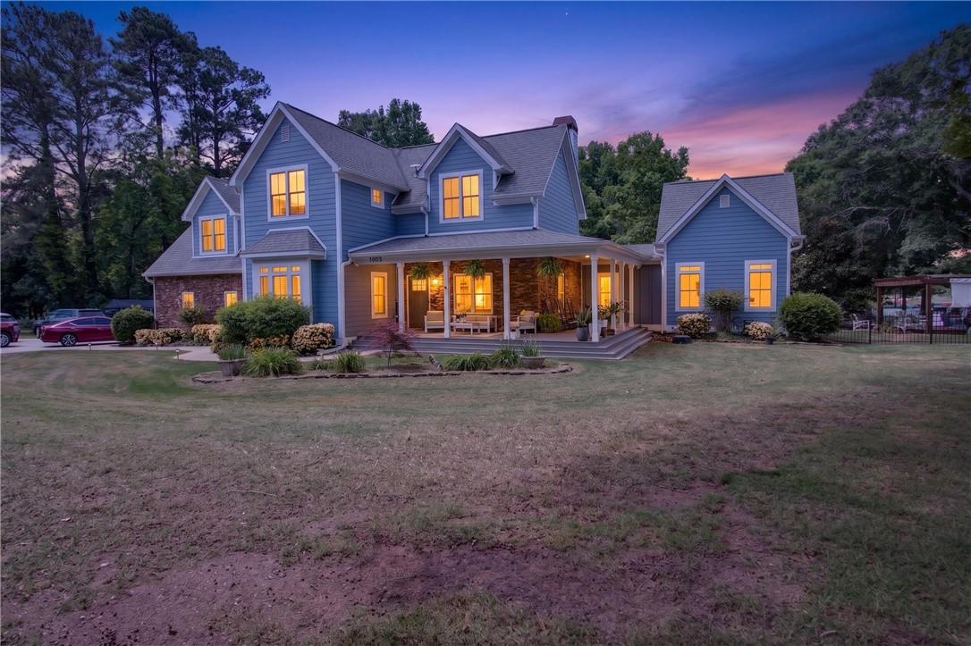 Image 1: This welcoming home features a broad front porch,